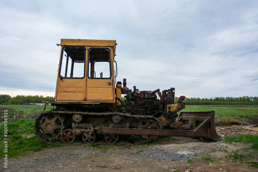 Broken tractor on tracks in the field Broken tractor on tracks in the field