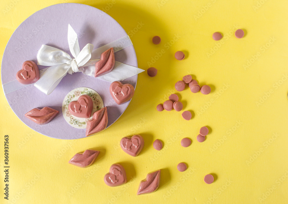 On a yellow background is a box with pink sweets. Place for photo.
On a yellow background is a box with pink sweets. Place for photo.