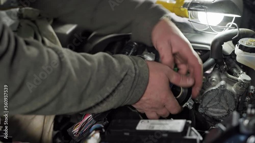 a man puts a protective cover on the wires and wraps insulating tape in the car