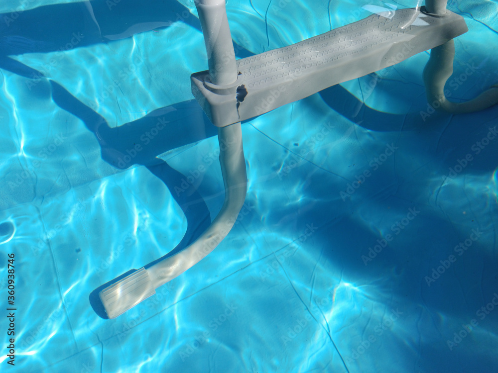 Close up of a grey pool ladder in a modern swimming pool
