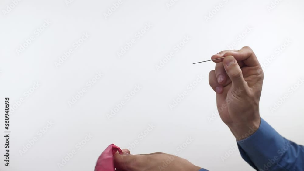 Man pierces a balloon with a needle Man pierces a balloon with a needle