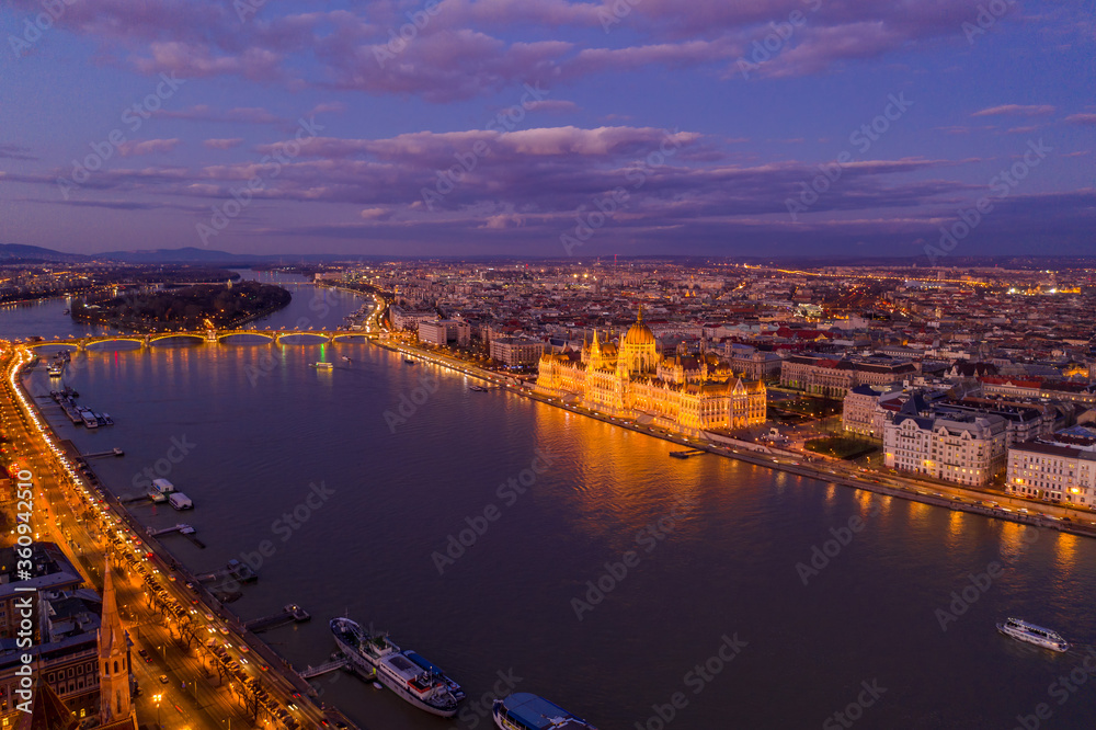 Aerial drone of lighted Hungarian Parliament by Danube river in