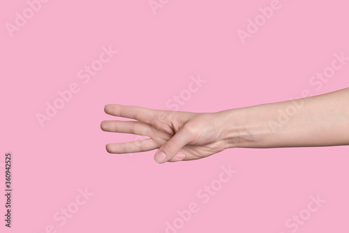 The number three. Caucasian hand on the right side, shows numbers on the fingers