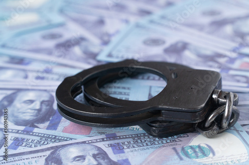 handcuffs against the background of hundred-dollar bills