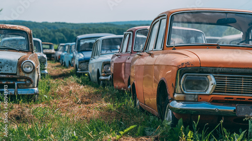 Many old abandoned and forgotten rusty vintage retro car in bad condition, panoramic view.