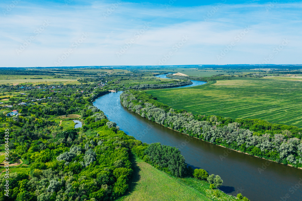 Beautiful green summer nature landscape with river and meadows, aerial view drone shot.