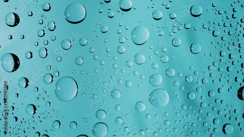 Water drops on turquoise colored glass window surface background. Clear transparent water droplets macro beading wallpaper