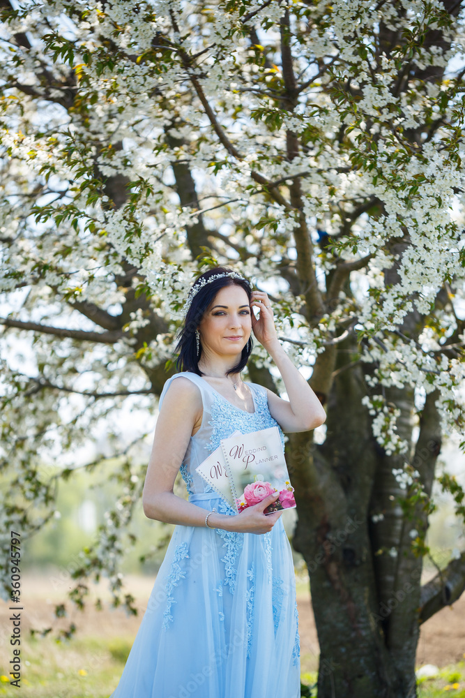 Young woman in a blue long dress holds a wedding glider in her hands Young woman in a blue long dress holds a wedding glider in her hands
