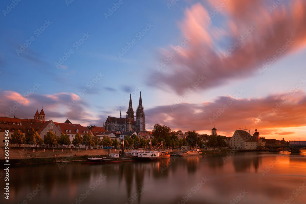 Regensburg am Donauufer mit dramatischen Himmel und spiegelung beim Sonnenuntergang