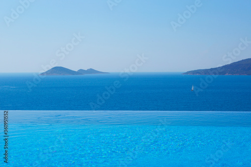 Infinity swimming pool with sea on bright summer day © isilterzioglu
