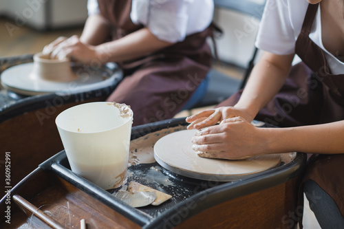 The manufacture of ceramics. Two woman prepare clay for work on pottery wheel. Close up view of hands.
