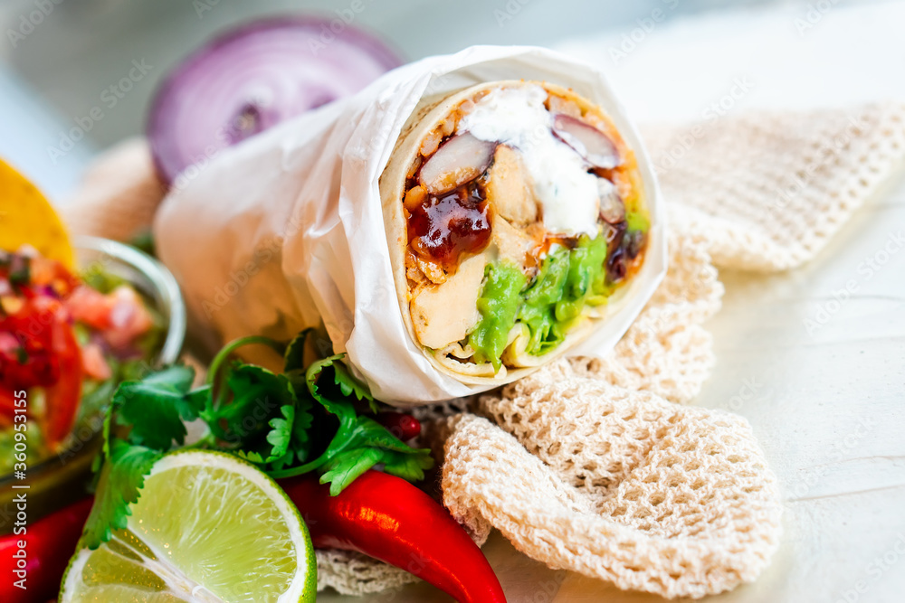 Mexican traditional authentic homemade Burrito with pulled pork beef chili con carne serve with tomato salad and avocado guacamole and dip sauce Mexican traditional authentic homemade Burrito with pulled pork beef chili con carne serve with tomato salad and avocado guacamole and dip sauce