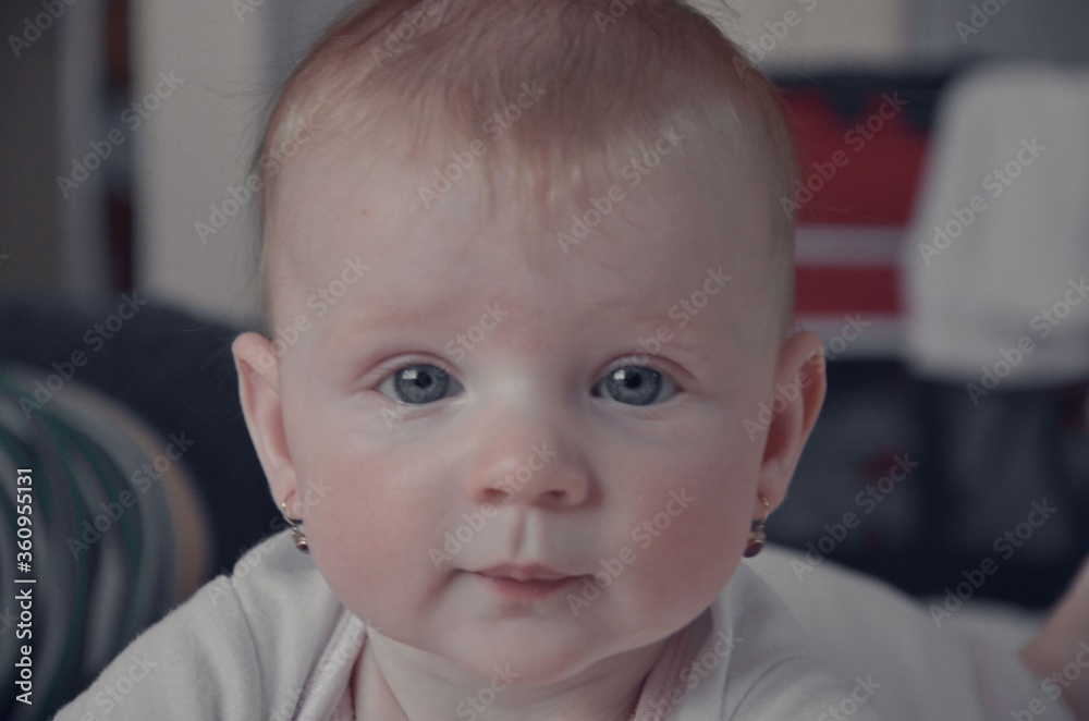 Cute little baby girl crawling on bed at home. Baby on bed - toddler baby girl crawls across bedlinen towards the camera. Close-up. Selective focus