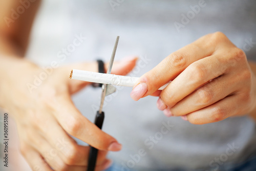 Stop smoking  close up of woman cuts a cigarette with scissors