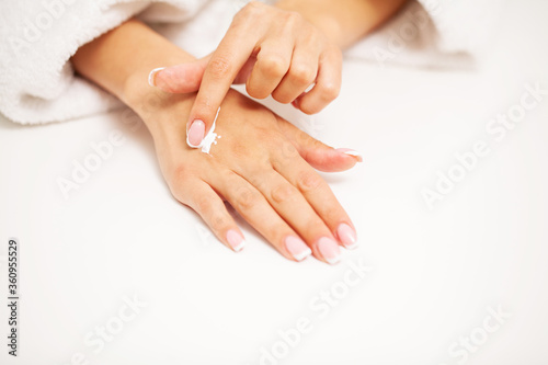 Hand skin care  woman applies moisturizer on soft silky skin