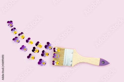 Fototapeta Naklejka Na Ścianę i Meble -  Creative spring, summer flowers composition with paint brush and pansies on pink background. flat lay, copy space, text