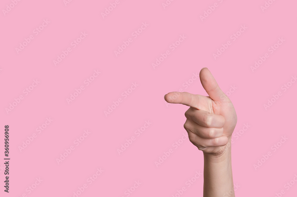 The hand shows the gesture of a gun or to the left. Isolated pink background.