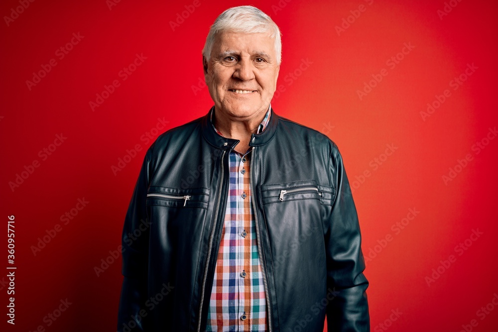 Senior handsome hoary man wearing casual shirt and jacket over isolated red background with a happy and cool smile on face. Lucky person.