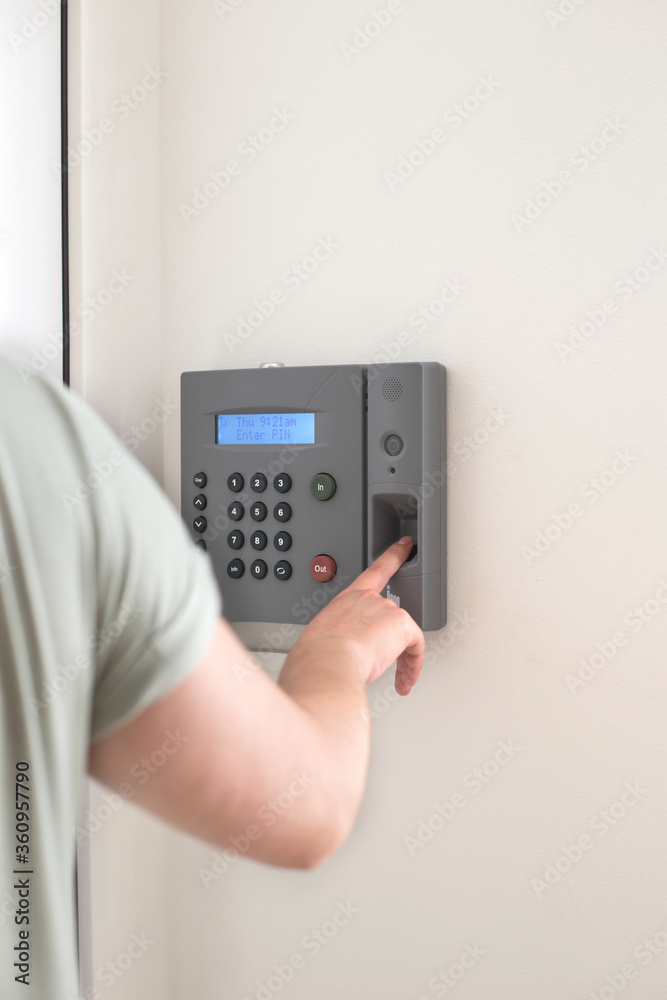 Side view of hand scanning fingerprint to screening system gain entry security to building. Biometric locks control access to record working time Side view of hand scanning fingerprint to screening system gain entry security to building. Biometric locks control access to record working time