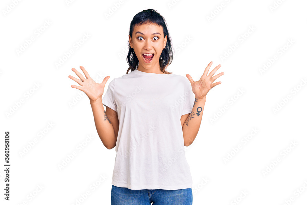 Young woman wearing casual clothes celebrating crazy and amazed for success with arms raised and open eyes screaming excited. winner concept Young woman wearing casual clothes celebrating crazy and amazed for success with arms raised and open eyes screaming excited. winner concept