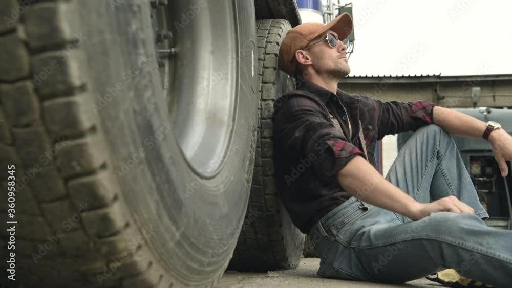 Commercial Truck Driver Sitting By His Automobile And Resting During Break Time. 