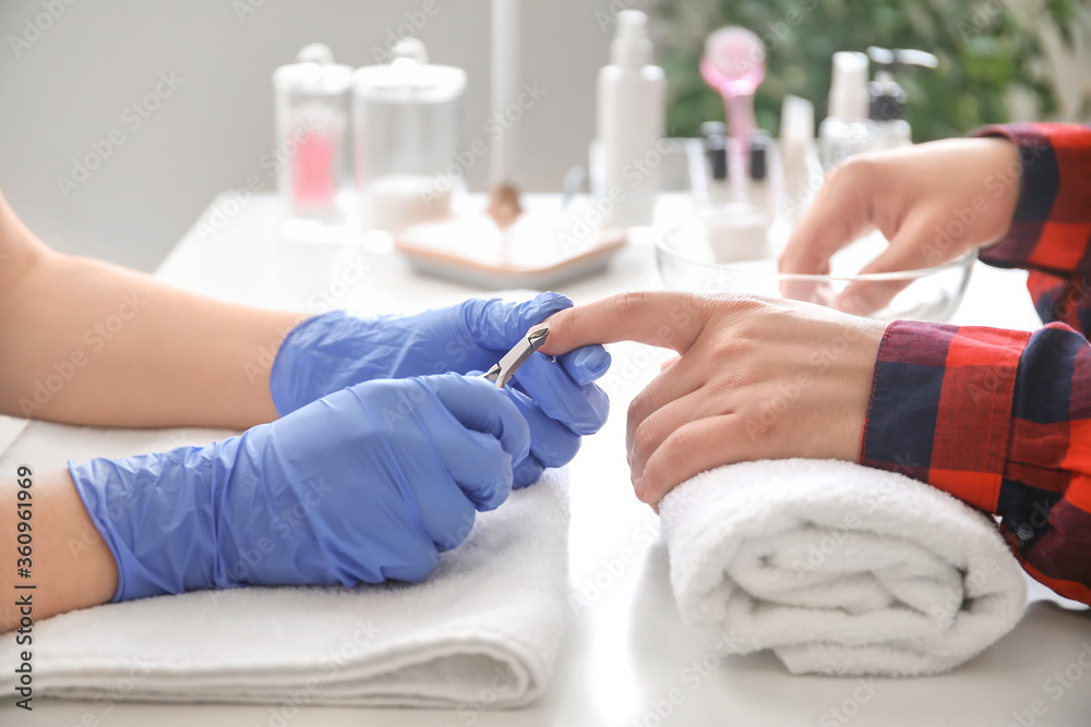 Manicure master working with male client in beauty salon, closeup Manicure master working with male client in beauty salon, closeup