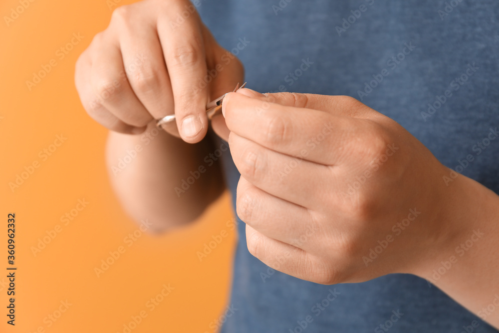Fototapeta premium Asian man doing manicure on color background, closeup