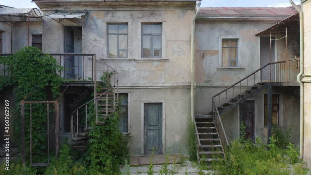 Abandoned houses in the courtyard (yard-well) of a ghost (haunted) town. Aerial low angle view Abandoned houses in the courtyard (yard-well) of a ghost (haunted) town. Aerial low angle view