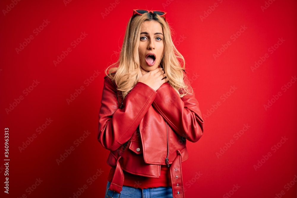 Young beautiful blonde woman wearing casual jacket standing over isolated red background shouting and suffocate because painful strangle. Health problem. Asphyxiate and suicide concept. Young beautiful blonde woman wearing casual jacket standing over isolated red background shouting and suffocate because painful strangle. Health problem. Asphyxiate and suicide concept.