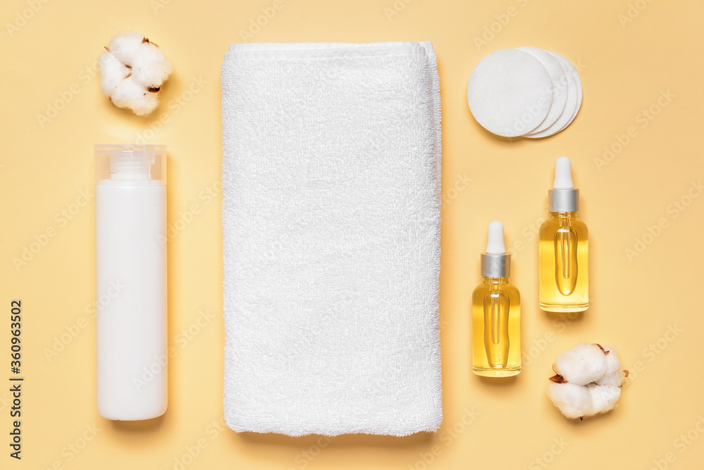 Cosmetics with towel on color background Cosmetics with towel on color background