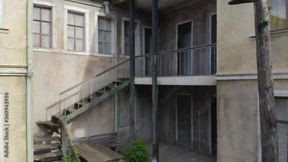 Abandoned houses in the courtyard (yard-well) of a ghost (haunted) town. Aerial low angle view Abandoned houses in the courtyard (yard-well) of a ghost (haunted) town. Aerial low angle view