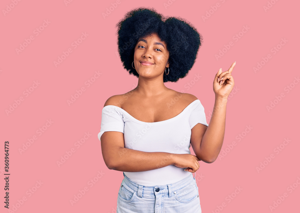Young african american girl wearing casual clothes smiling happy pointing with hand and finger to the side Young african american girl wearing casual clothes smiling happy pointing with hand and finger to the side