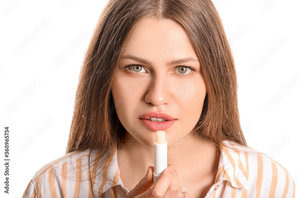 Beautiful young woman with lip balm on white background Beautiful young woman with lip balm on white background