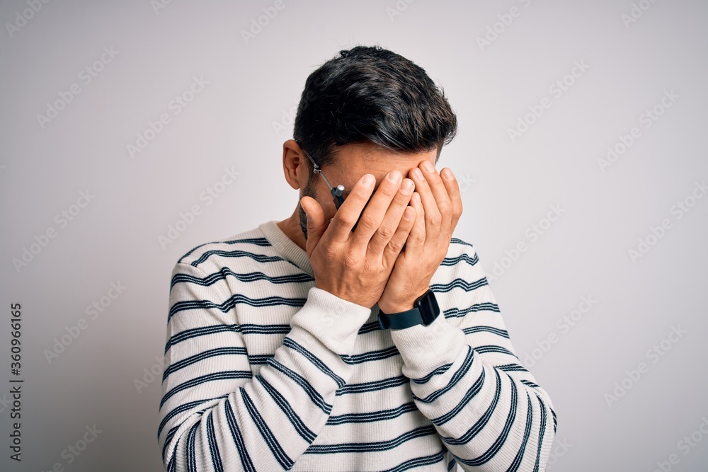 Young handsome man with beard wearing optometry glasses over isolated white background with sad expression covering face with hands while crying. Depression concept. Young handsome man with beard wearing optometry glasses over isolated white background with sad expression covering face with hands while crying. Depression concept.