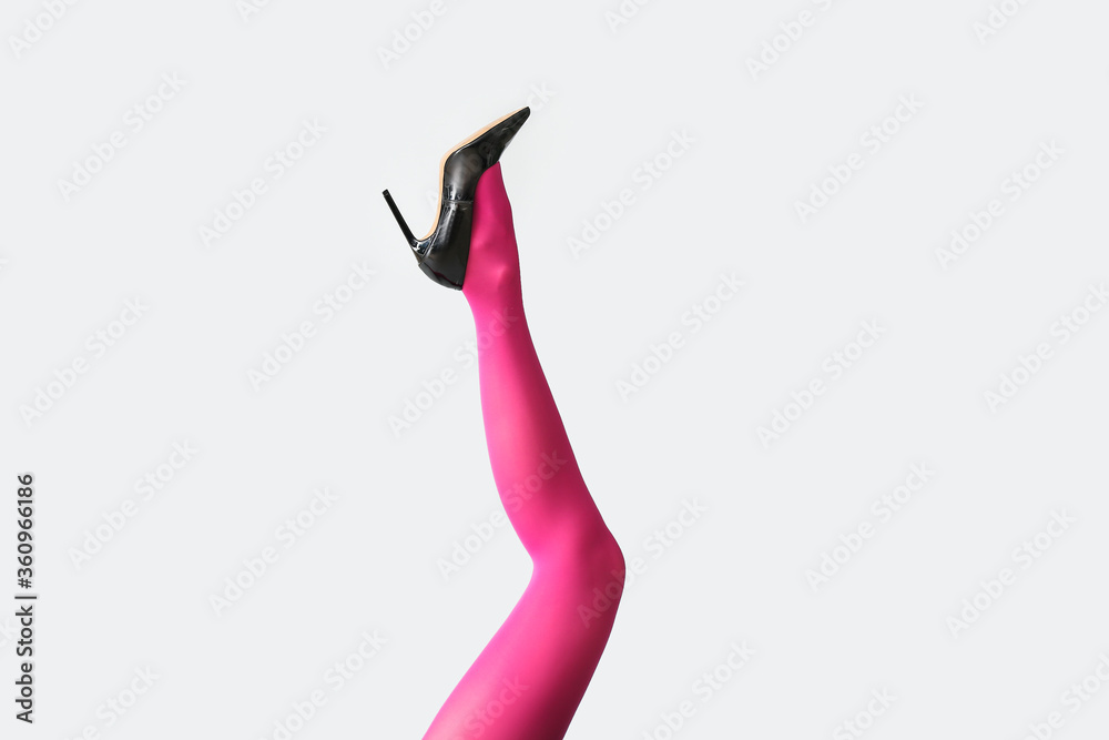 Obraz premium Beautiful young woman in tights on light background