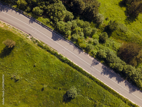 Aerial view top down from above on the country road in mountain range in between green grass and trees around - nature travel concept drone photo on Stara Planina Old Mountain in Europe Serbia