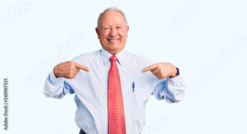 Senior handsome grey-haired man wearing elegant tie and shirt looking confident with smile on face, pointing oneself with fingers proud and happy.