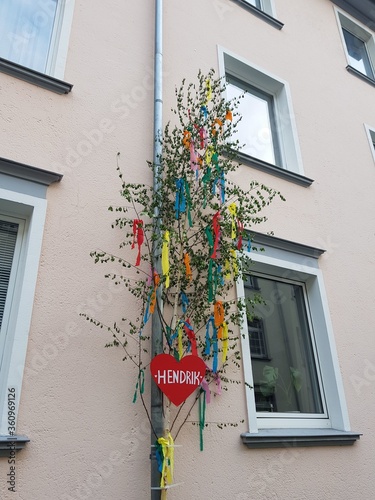 Fényképezés Vertical shot of a maypole with a red heart on the building