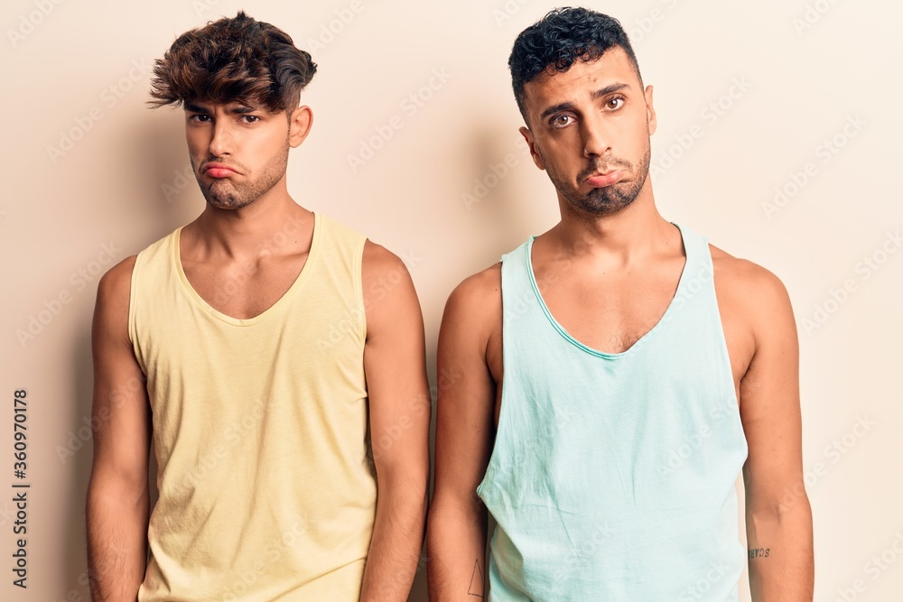 Young gay couple wearing casual clothes depressed and worry for distress, crying angry and afraid. sad expression. Young gay couple wearing casual clothes depressed and worry for distress, crying angry and afraid. sad expression.