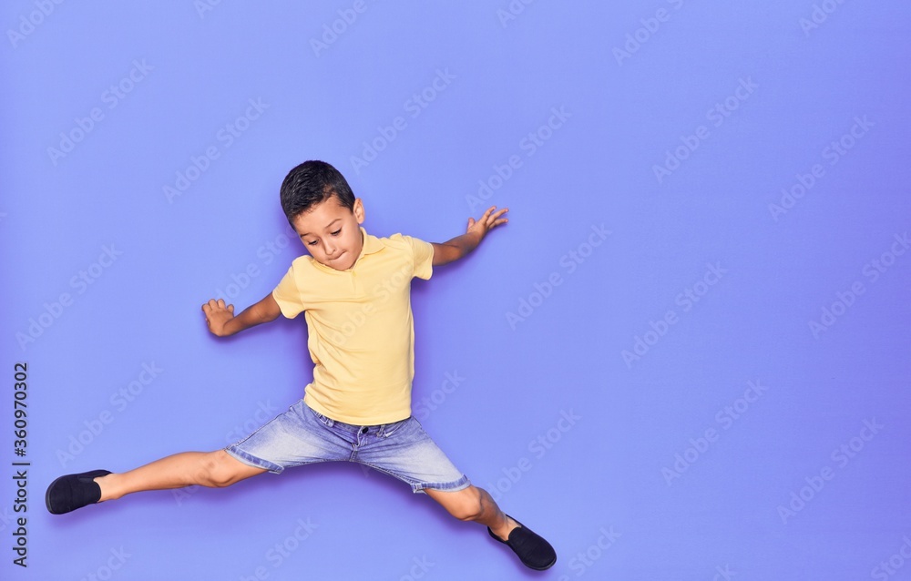 Adorable kid wearing casual clothes jumping over isolated purple background Adorable kid wearing casual clothes jumping over isolated purple background
