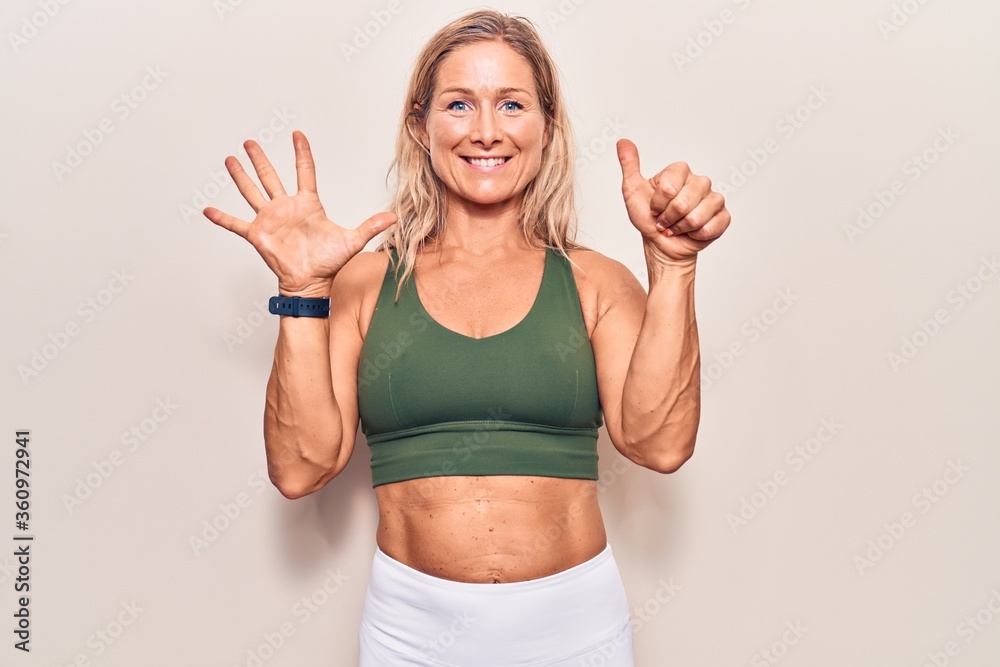 Middle age caucasian blonde woman wearing sportswear showing and pointing up with fingers number six while smiling confident and happy. Middle age caucasian blonde woman wearing sportswear showing and pointing up with fingers number six while smiling confident and happy.