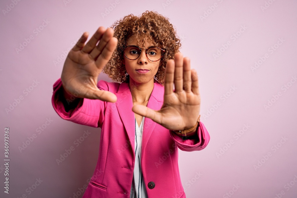 Young african american businesswoman wearing glasses standing over pink background doing frame using hands palms and fingers, camera perspective Young african american businesswoman wearing glasses standing over pink background doing frame using hands palms and fingers, camera perspective