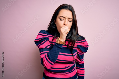 Young brunette elegant woman wearing striped shirt over pink isolated background feeling unwell and coughing as symptom for cold or bronchitis. Health care concept. © Krakenimages.com
