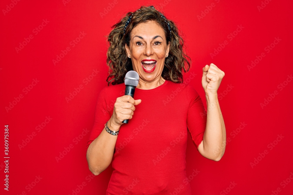 Middle age senior singer woman singing using music microphone over red background screaming proud and celebrating victory and success very excited, cheering emotion Middle age senior singer woman singing using music microphone over red background screaming proud and celebrating victory and success very excited, cheering emotion