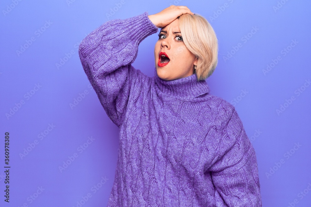 Beautiful blonde plus size woman wearing casual turtleneck sweater over purple background surprised with hand on head for mistake, remember error. Forgot, bad memory concept. Beautiful blonde plus size woman wearing casual turtleneck sweater over purple background surprised with hand on head for mistake, remember error. Forgot, bad memory concept.
