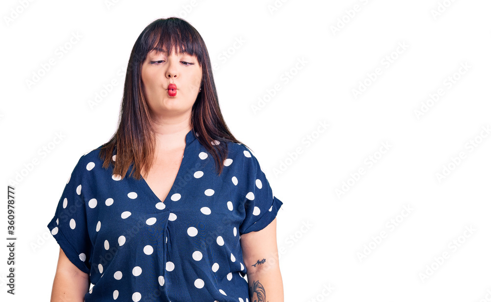 Young plus size woman wearing casual clothes making fish face with lips, crazy and comical gesture. funny expression. Young plus size woman wearing casual clothes making fish face with lips, crazy and comical gesture. funny expression.