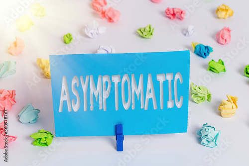 Writing note showing Asymptomatic. Business concept for a condition or an individual producing or showing no symptoms Colored crumpled paper empty reminder white floor clothespin photo