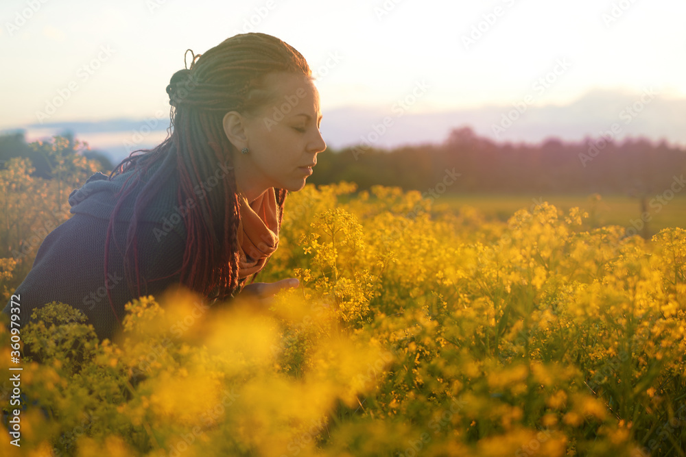 Fototapeta premium red-haired girl in a field of diverse flowers. the concept of freedom, relaxation, enjoyment of the world. and free breathing without allergies
