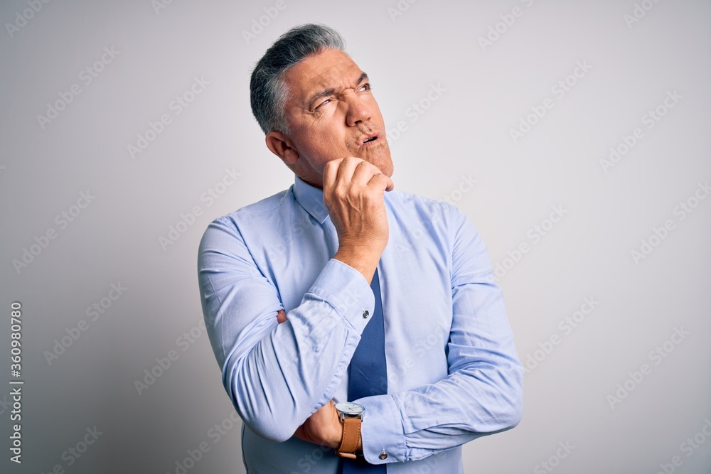Middle age handsome grey-haired business man wearing elegant shirt and tie Thinking worried about a question, concerned and nervous with hand on chin Middle age handsome grey-haired business man wearing elegant shirt and tie Thinking worried about a question, concerned and nervous with hand on chin
