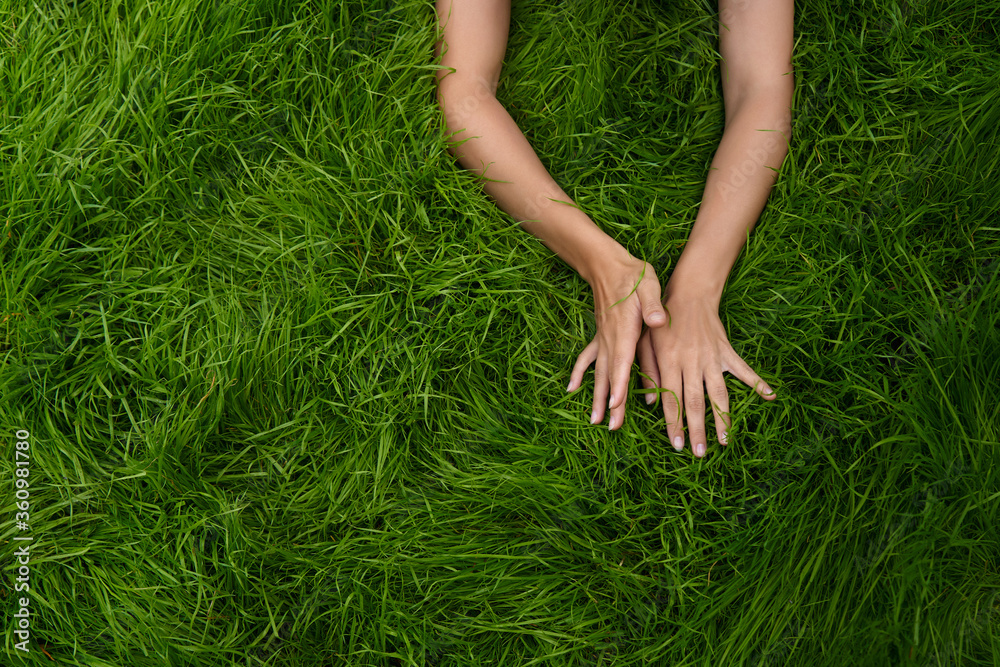 female hands lie in different positions on the green grass. the concept of the unification of nature and man, natural cosmetics and natural beauty female hands lie in different positions on the green grass. the concept of the unification of nature and man, natural cosmetics and natural beauty